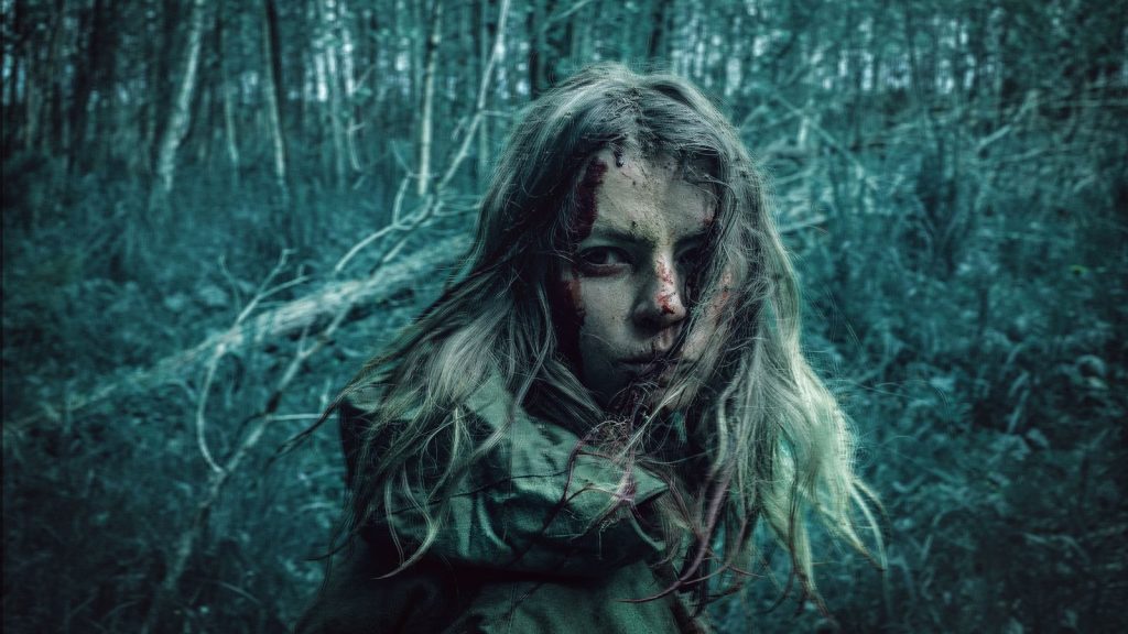A dramatic portrait of a distressed woman in a dark, eerie forest setting.