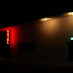 Exterior of an illuminated hotel with neon signs at night in Marfa, Texas.