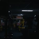A dark and eerie arcade featuring retro game machines under a "CHANGE" sign.