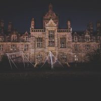 A nighttime photograph of an eerie, abandoned mansion in Wales, exuding a spooky atmosphere.