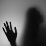 a shadow of a person holding their hand up