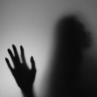 a shadow of a person holding their hand up