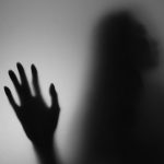 a shadow of a person holding their hand up