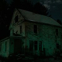 an old house is lit up in the dark