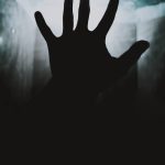 a person's hand reaching up into the air
