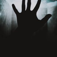 a person's hand reaching up into the air