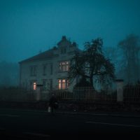 person walking towards house