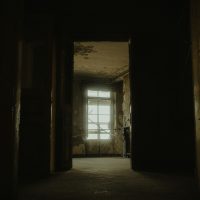 Explore the eerie interior of an abandoned building, capturing its desolate charm.