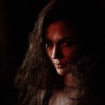 Dark portrait of a woman with mystic and gothic elements, evoking a serious mood.