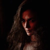 Dark portrait of a woman with mystic and gothic elements, evoking a serious mood.