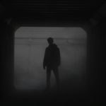 silhouette of man standing in front of window